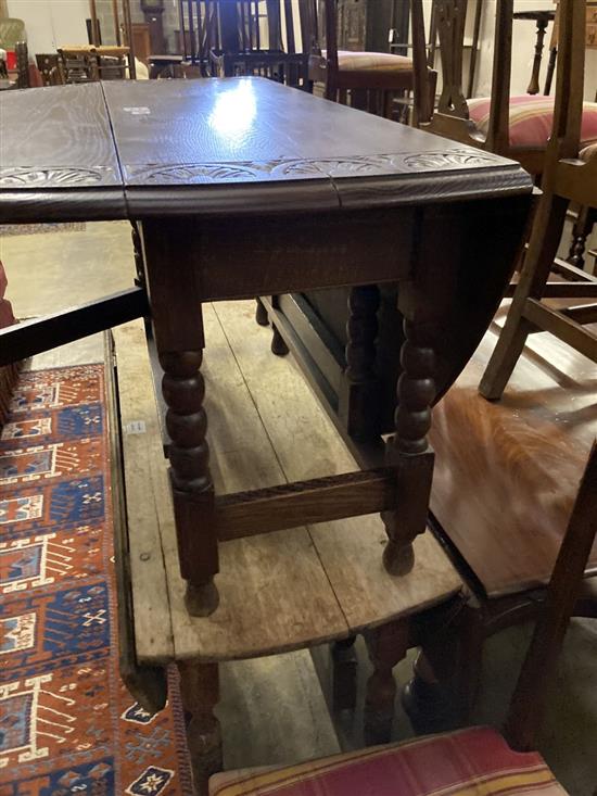 A low oak oval topped gateleg table, width 105cm extended 130cm height 51cm